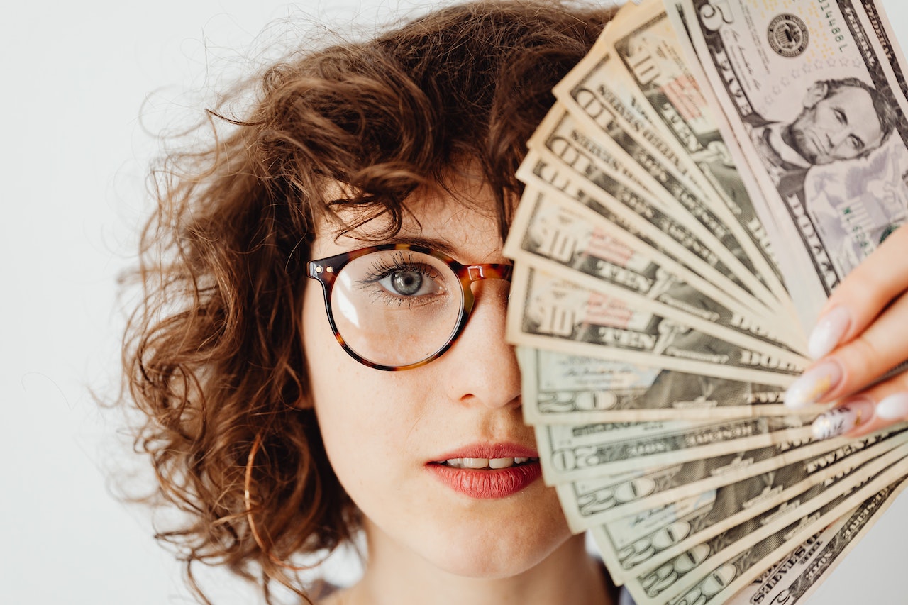 Personalkosten als Investitionsentscheidung - Frau mit Geldfächer